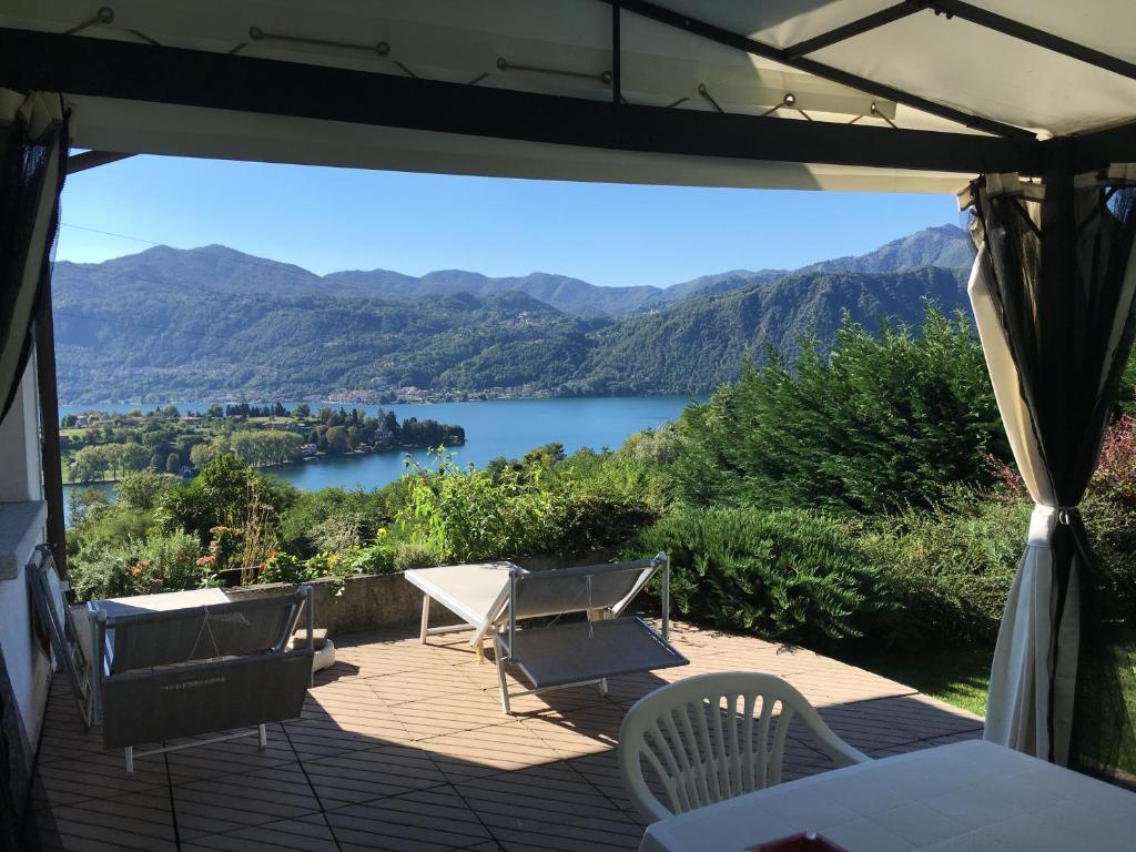 a patio with a view of a lake and mountains at La Maisonette in Miasino