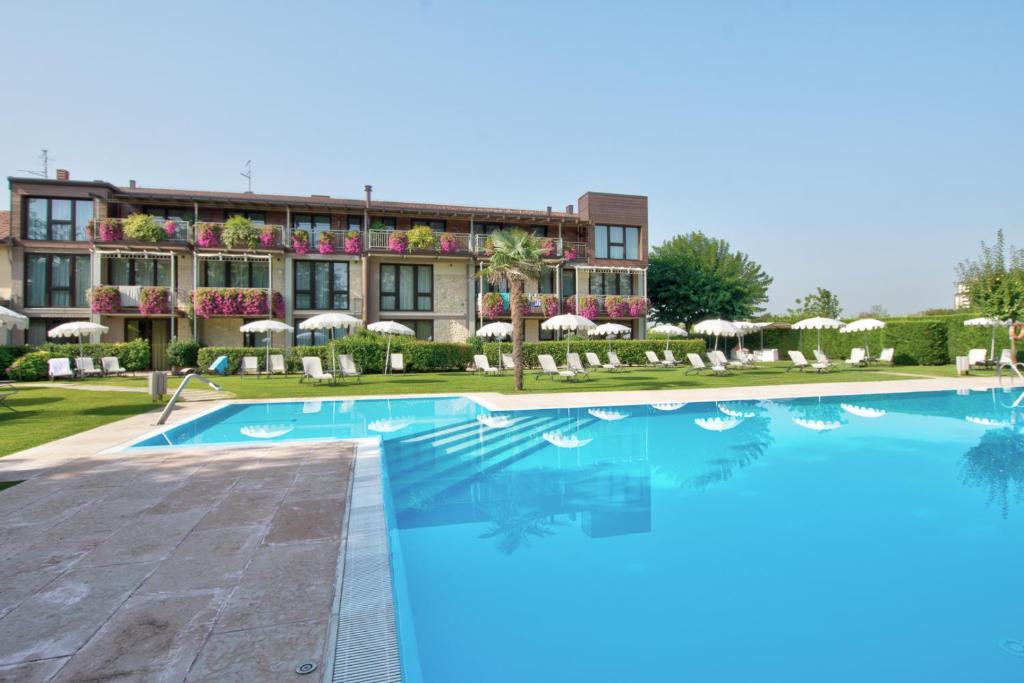 a hotel with a swimming pool in front of a building at Cà dell'Orto Rooms & Apartments in Verona