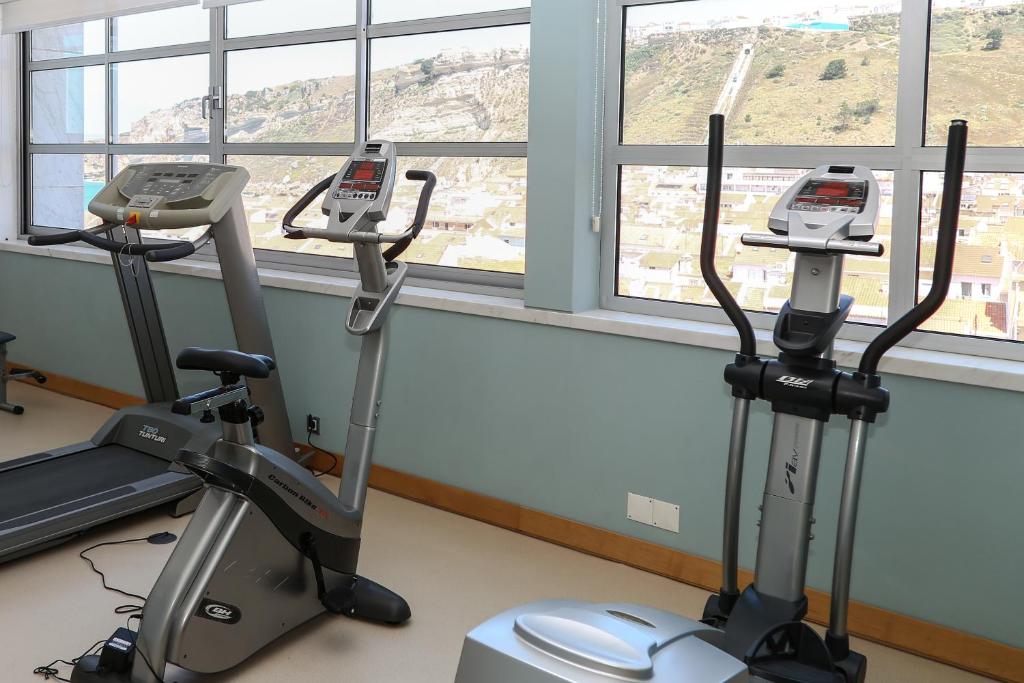 a gym with two exercise bikes in front of a window at Hotel Praia in Nazaré