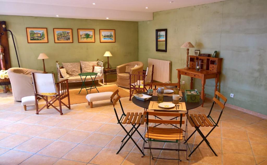 a living room with chairs and a table and a couch at Le Clos des Pierres Dorées in Theizé