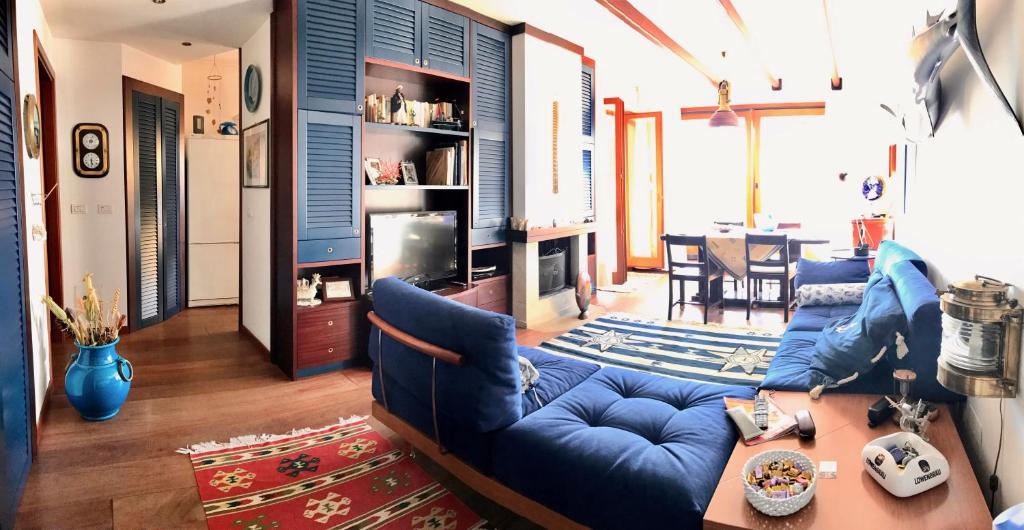 un soggiorno con un divano blu e un tavolo di Vest House 45 ad Alghero