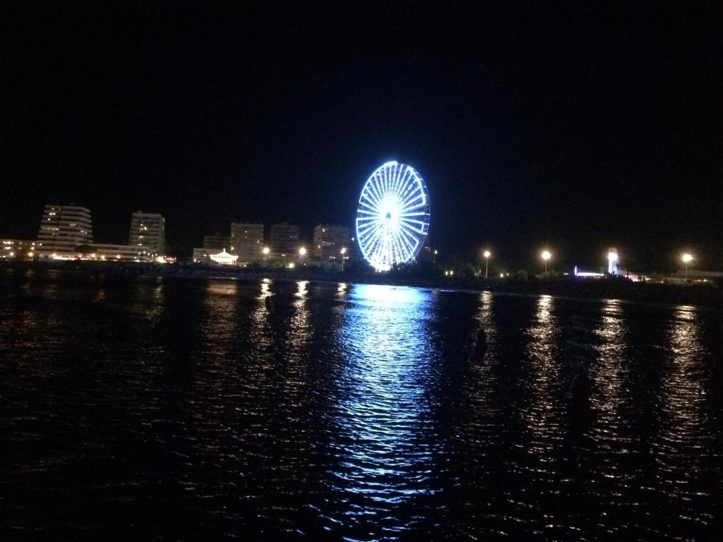 une roue ferris allumée la nuit à côté de l'eau dans l'établissement Bleu Soleil, à La Grande Motte