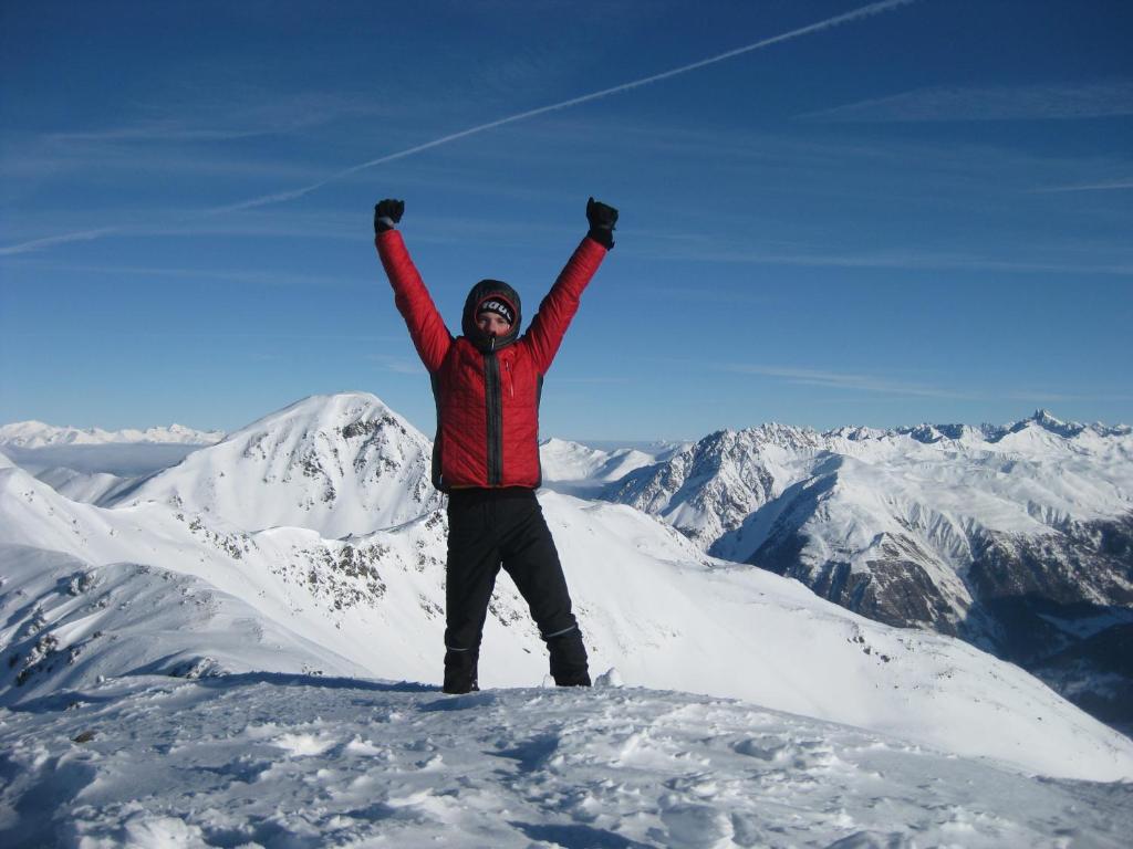 un hombre parado en la cima de una montaña cubierta de nieve en Haus Vlcek, en Nauders