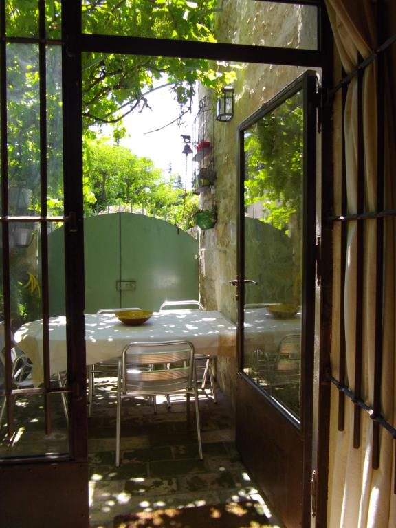 an open door to a patio with a table and chairs at Maison de charme pittoresque Villeneuve lez Avignon in Villeneuve-lès-Avignon