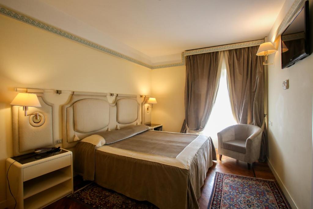 a hotel room with two beds and two lamps at Grand Hotel Tettuccio in Montecatini Terme
