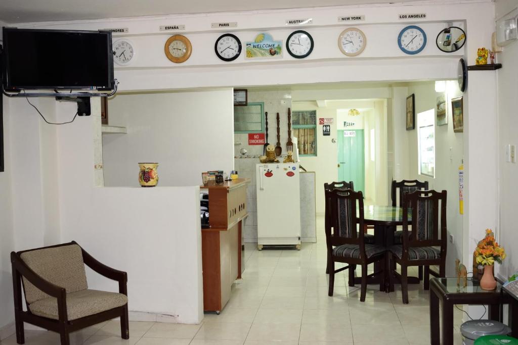 a kitchen with a table and chairs and clocks on the wall at Cafe Inn Casa Hotel in Montenegro