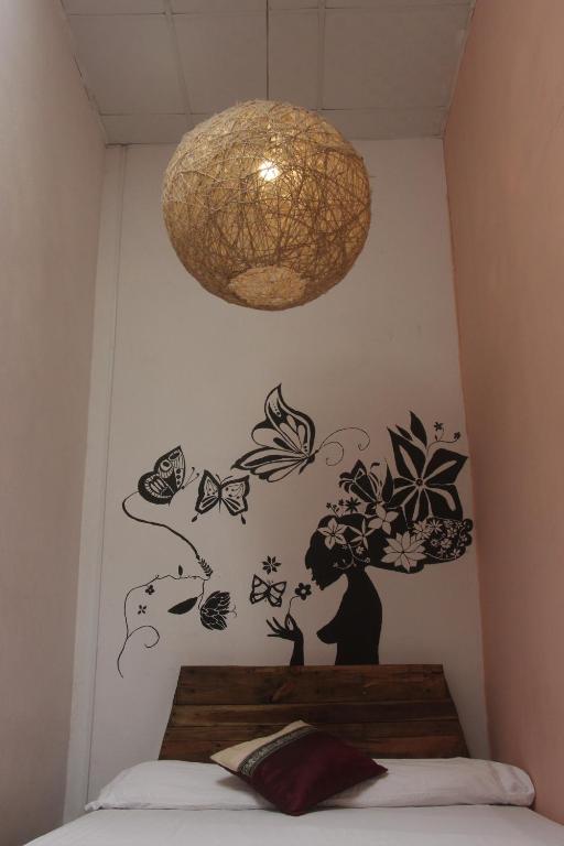 a bedroom with a wall with butterflies and a lamp at Bodhi Hostel & Lounge in Valle de Anton