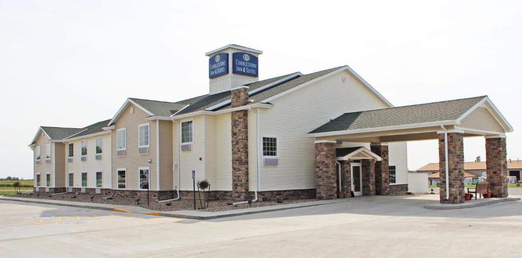 a large white building with a clock tower on top at Cobblestone Inn & Suites - Lamoni in Lamoni