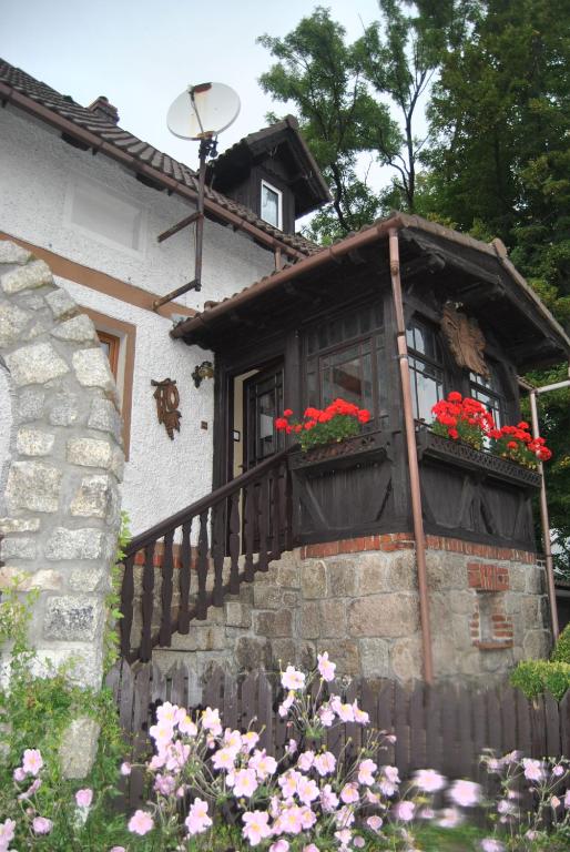 a house with a balcony with red flowers on it at Apartament w Karkonoszach in Miłków