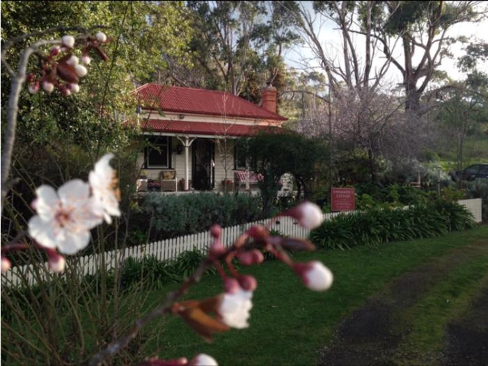 a house with a fence and flowers in the yard at Sinnamons Cottage in Maldon