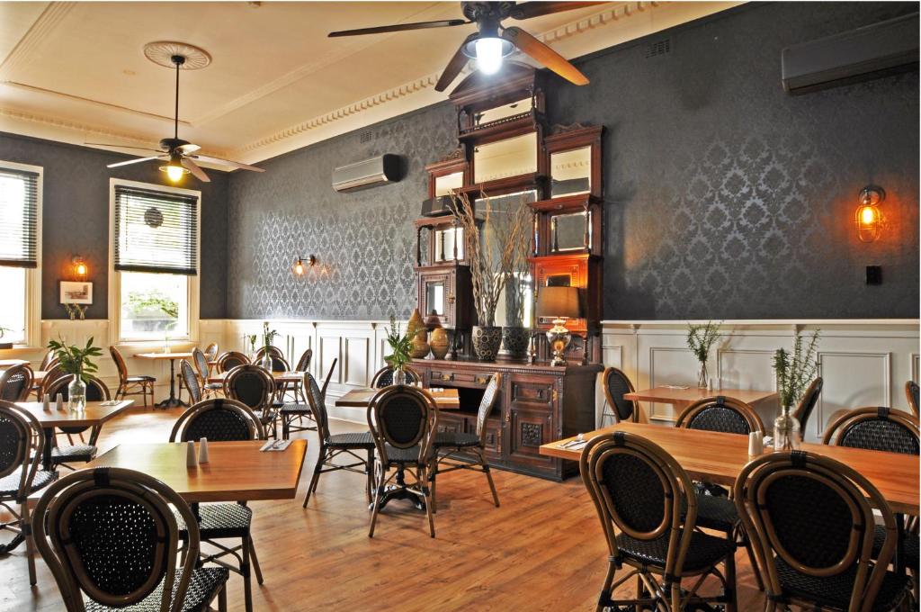 a restaurant with tables and chairs in a room at Grand Hotel Healesville in Healesville