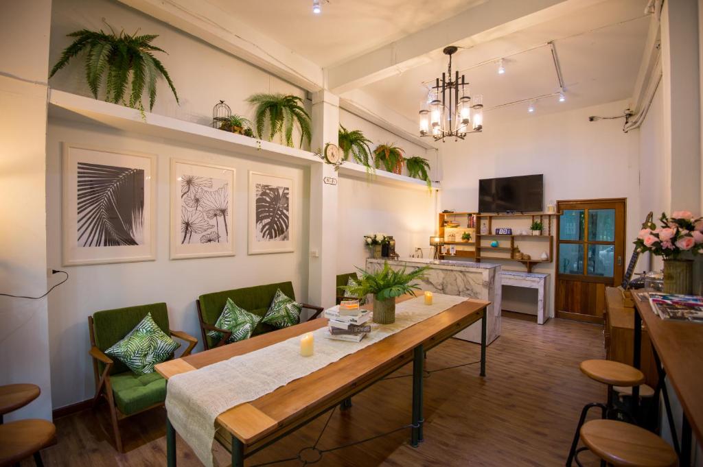 a living room with a table and green chairs at Victory Park Hostel in Bangkok