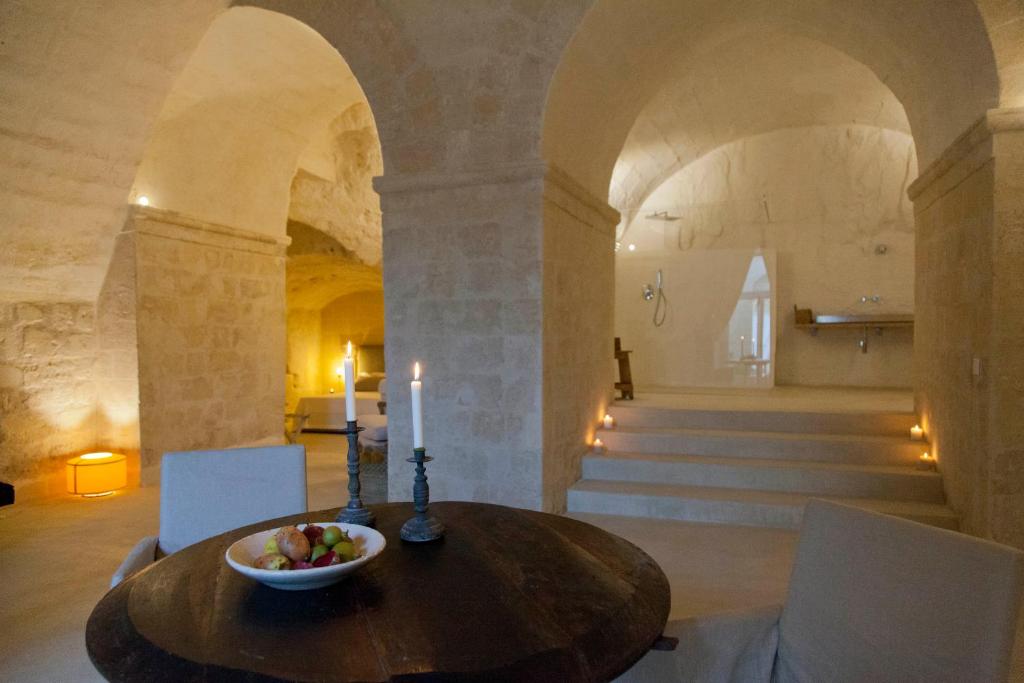 a room with a table with a bowl of fruit on it at Angolo del poeta suite in Matera