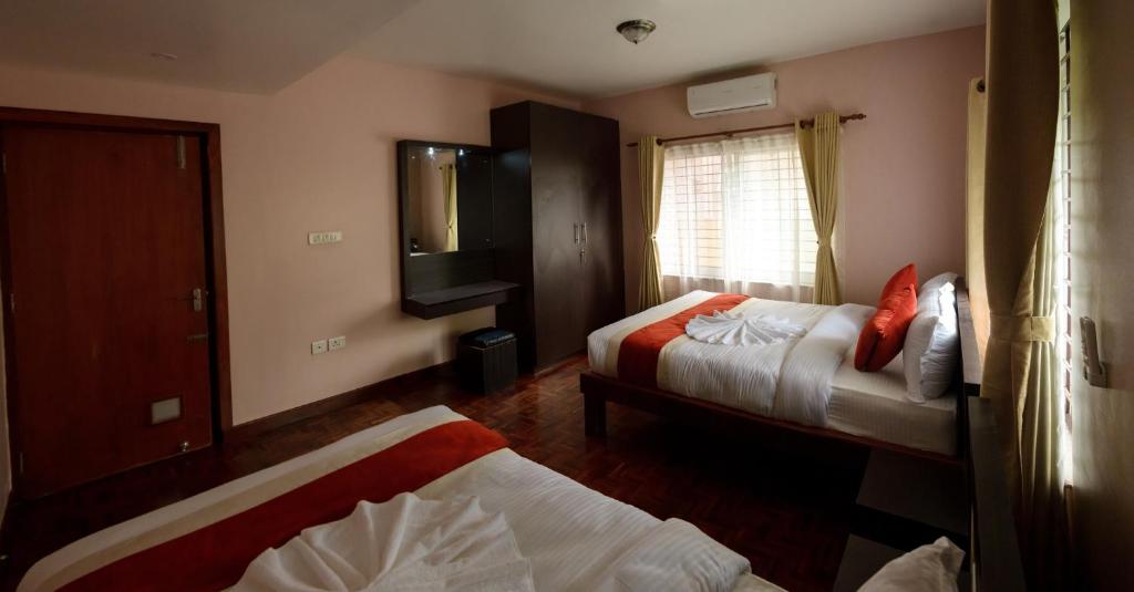 a hotel room with two beds and a television at Sweet Dream Apartment in Kathmandu