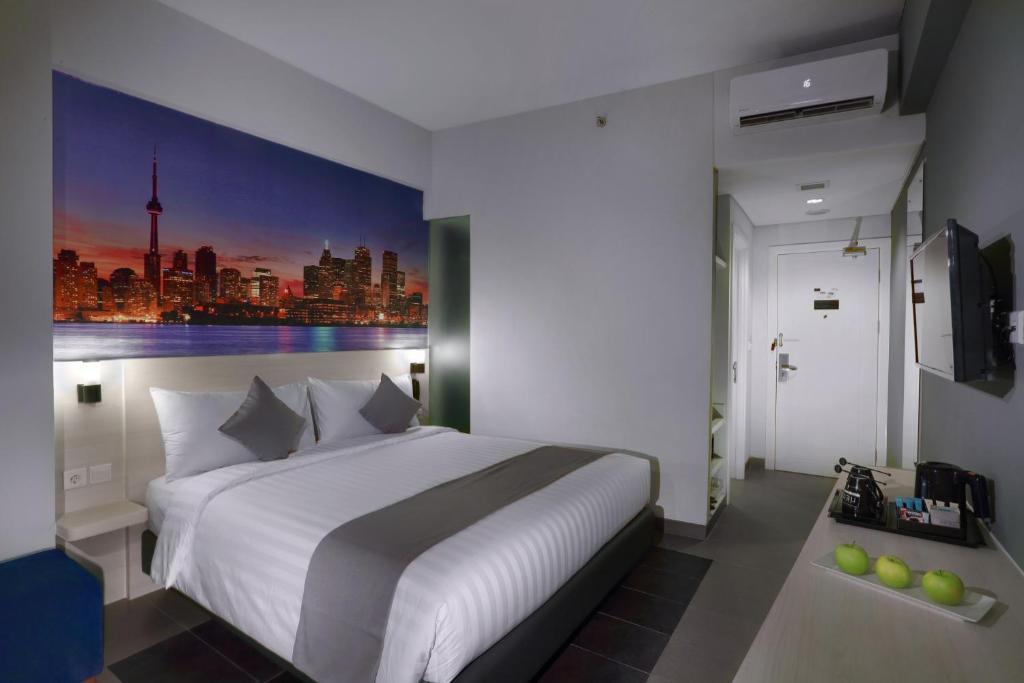 雅加達的住宿－雅加達克巴約藍尼奧酒店，卧室配有一张白色大床,墙上挂有绘画作品
