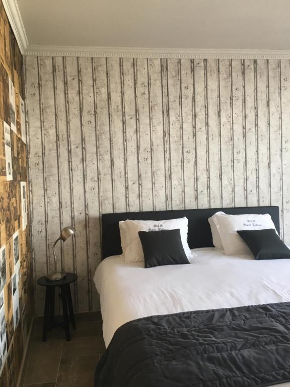 een slaapkamer met 2 bedden en een gestreepte muur bij B&B Le Grand Cabaret in Nieuwpoort