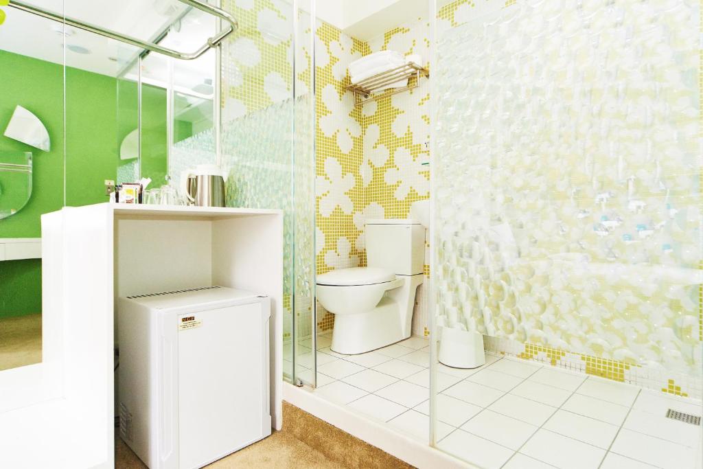 a bathroom with a toilet and a glass shower at Forever Inn in Taipei