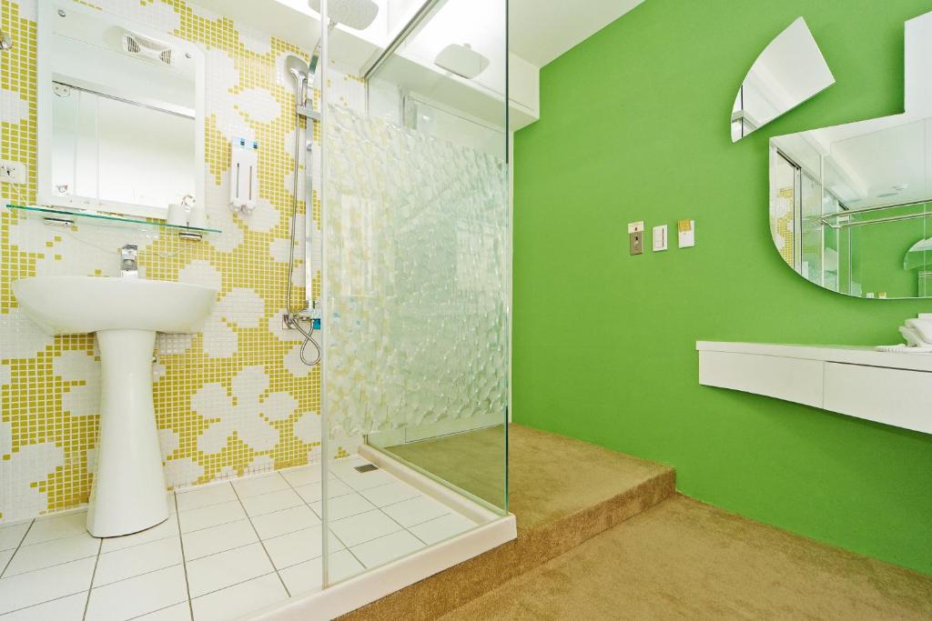 a green bathroom with a sink and a shower at Forever Inn in Taipei