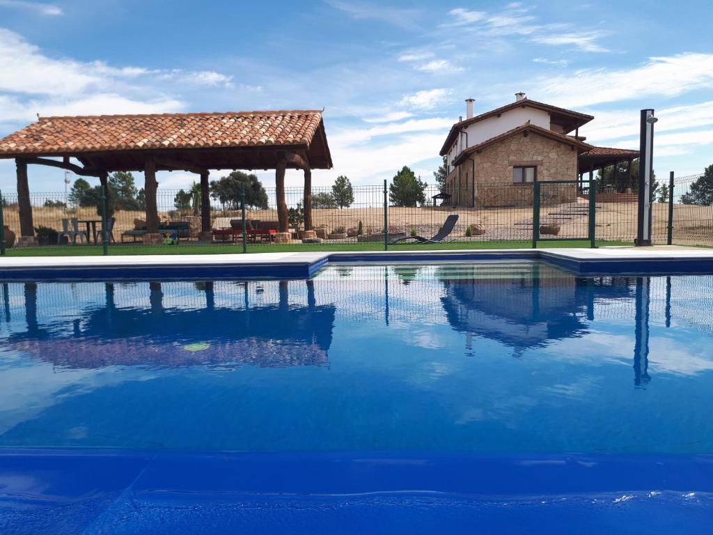 a swimming pool with a gazebo and a house at Sakura Vera in Villanueva de la Vera