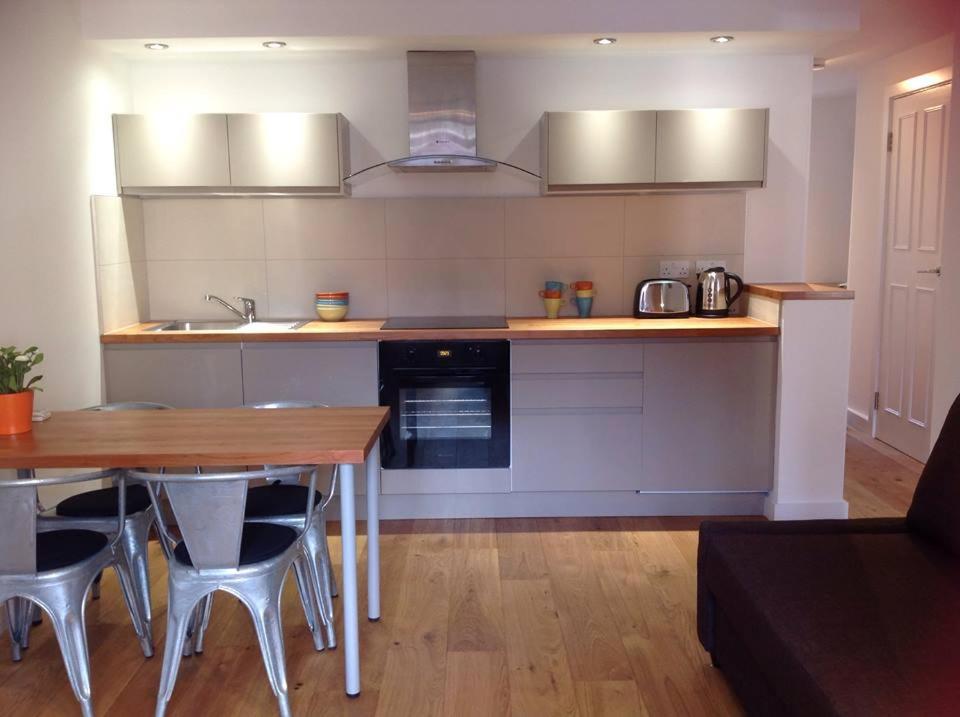 a kitchen with a wooden table and a counter top at Farriers House in London