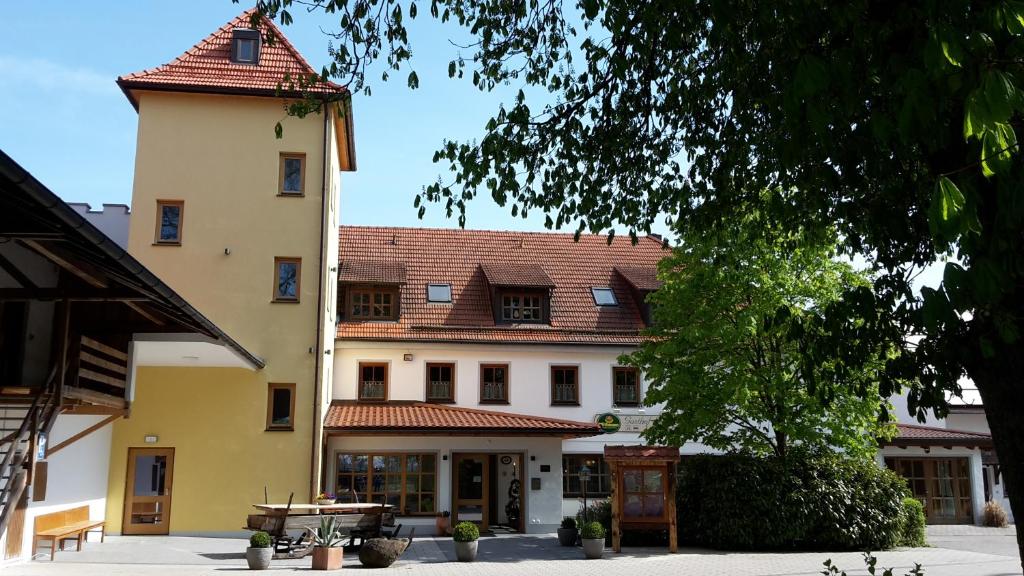 ein großes gelbes Gebäude mit rotem Dach in der Unterkunft Gasthof Sempt in Spörerau