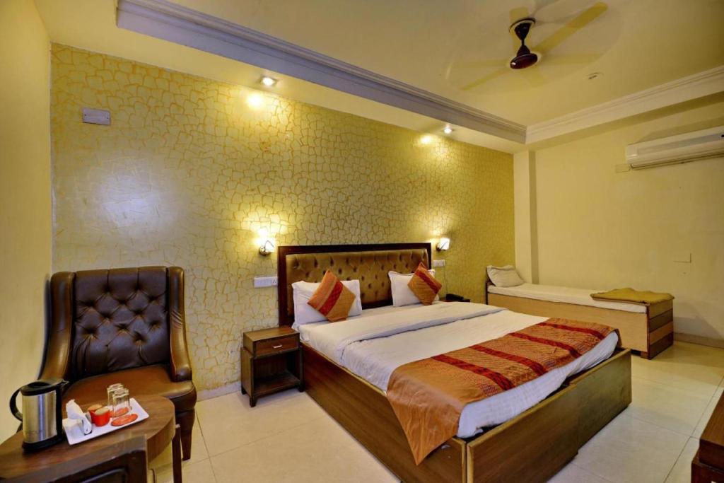 um quarto de hotel com uma cama e uma cadeira em Hotel Diamond Inn em Chandīgarh