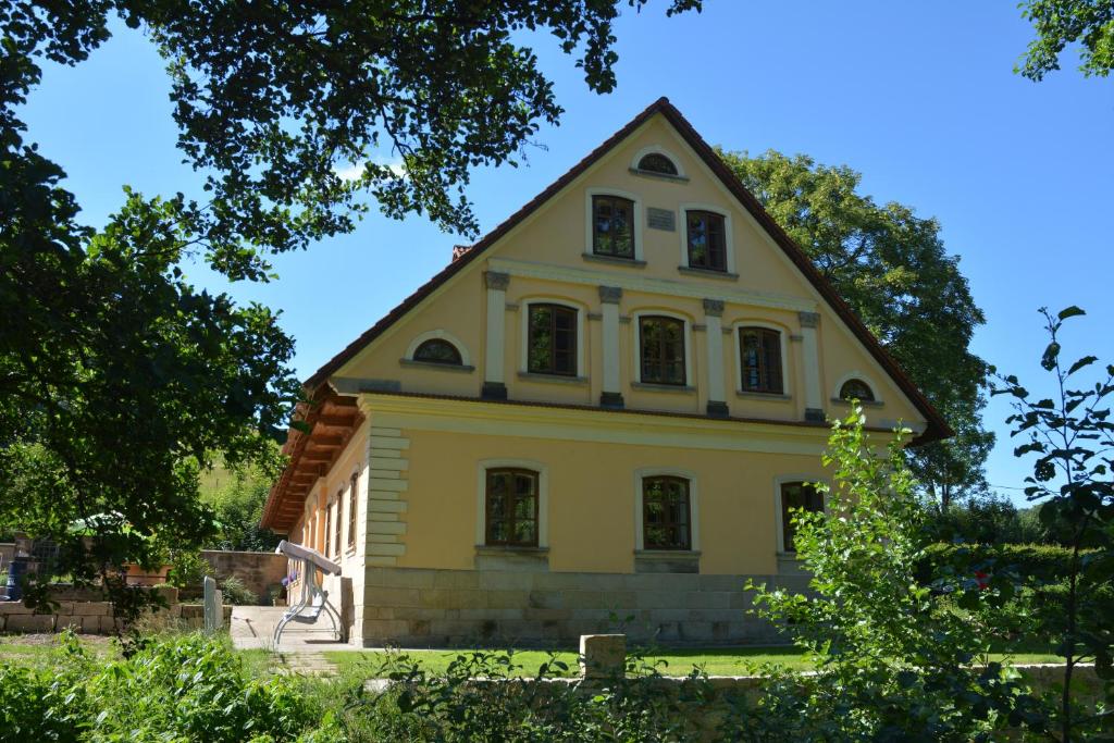 una casa amarilla con techo de gambrel en Bělský Dvůr, en Bělý
