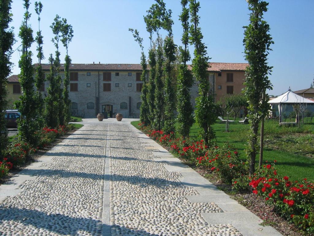 a walkway in front of a building with trees and flowers at Albergo Villa Francesca Beauty Spa in Calvisano