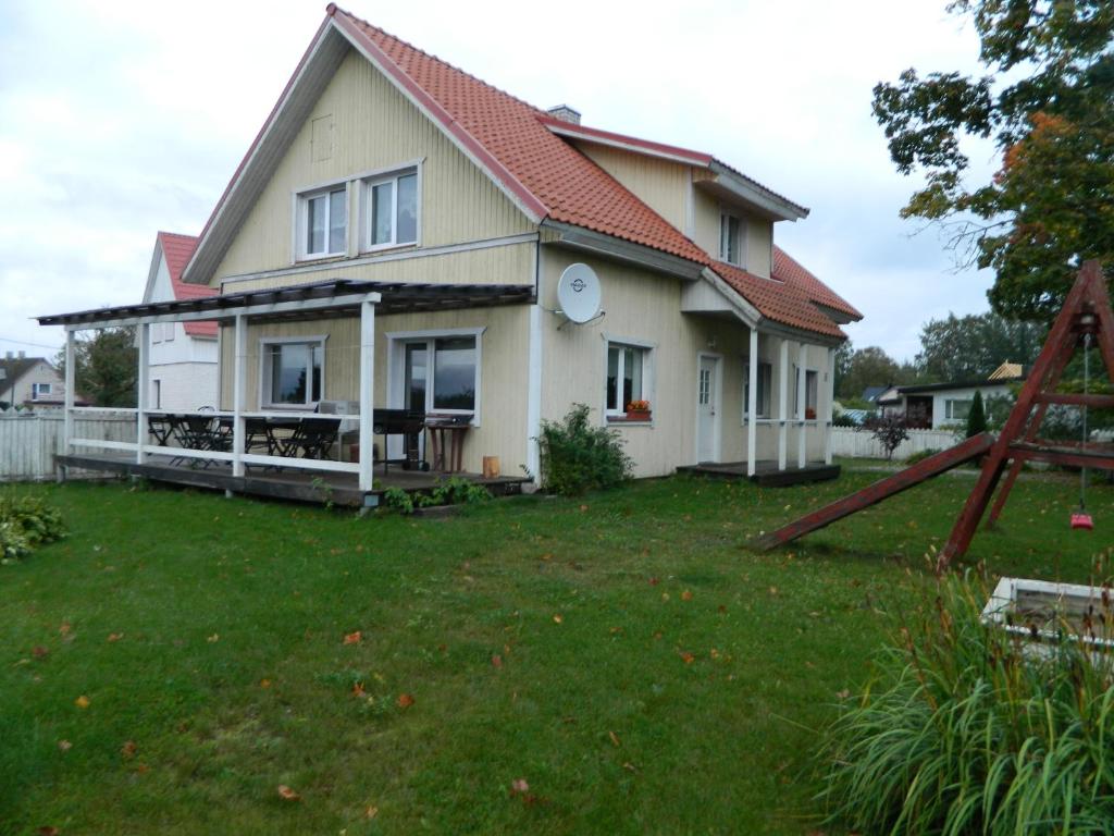 Casa blanca con techo rojo y patio en Guesthouse Valentini, en Otepää
