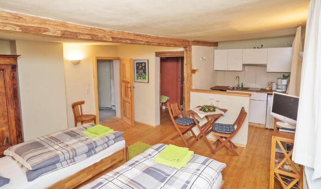 ナウムブルクにあるApartment Naumburgのベッド2台とキッチンが備わる小さな客室です。