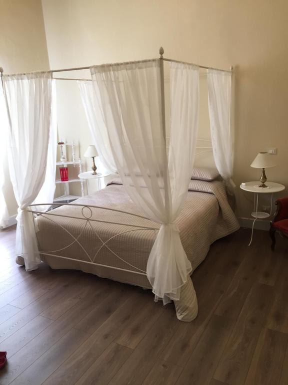 アルベンガにあるResidenza d'Asteのベッドルーム(白いカーテン付きの天蓋付きベッド1台付)