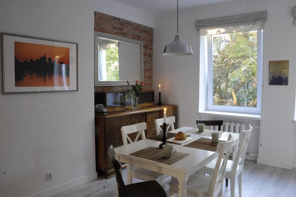 a dining room with a white table and chairs at MiłoTu - Apartament Marszałkowski in Warsaw