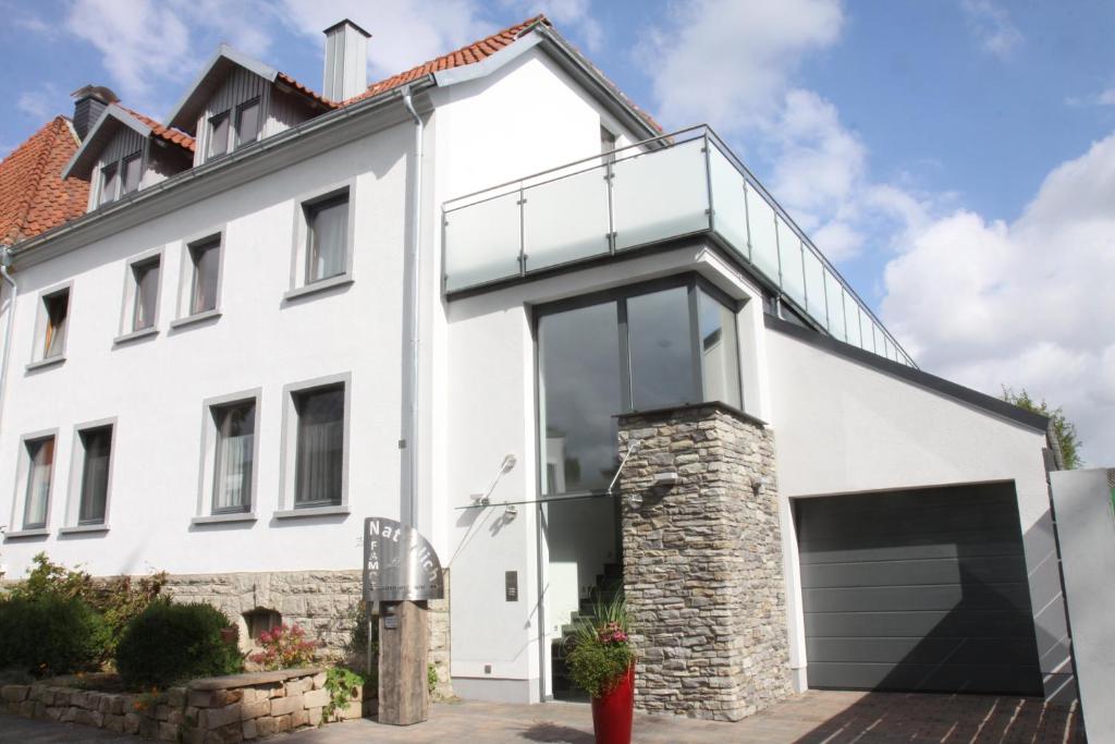Cette maison blanche dispose d'un balcon. dans l'établissement FAMOS Schlafen, à Warburg