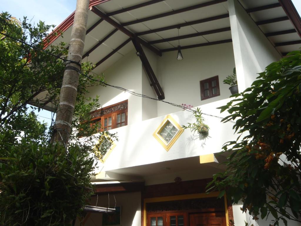 本托塔的住宿－New Jaya Villa，前面有棵树的白色建筑