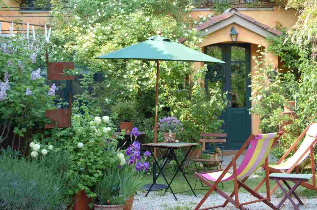 a garden with a table and chairs and an umbrella at B&B Binot in Carmagnola