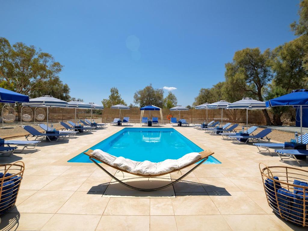 a pool with chaise lounge chairs and a swimming pool at Thalasea Kimolos - Θalasea - PS Rental in Kimolos