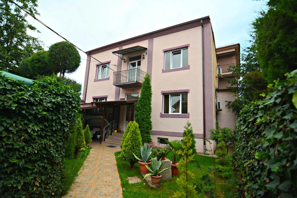 a pink building with plants in front of it at Guest House Via in Bitola