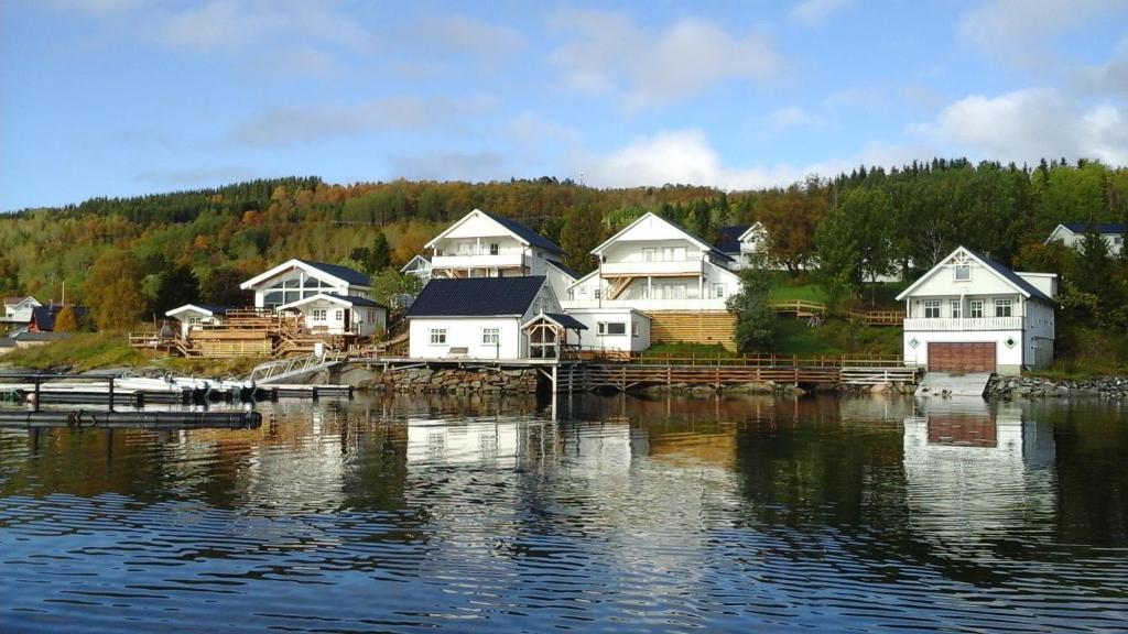a group of houses on the shore of a body of water at Furoy Fishingcamp and Hotel Apartments in Sorreisa