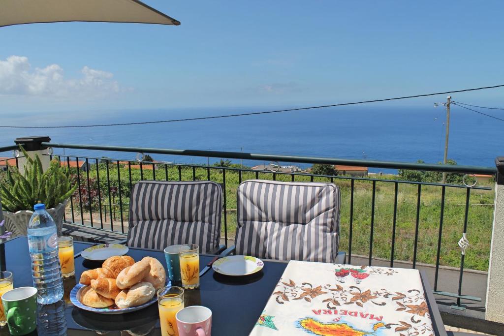 ein Tisch mit einem Teller Essen auf einem Balkon in der Unterkunft OurMadeira - Casa Vista Bela, countryside in Estreito da Calheta