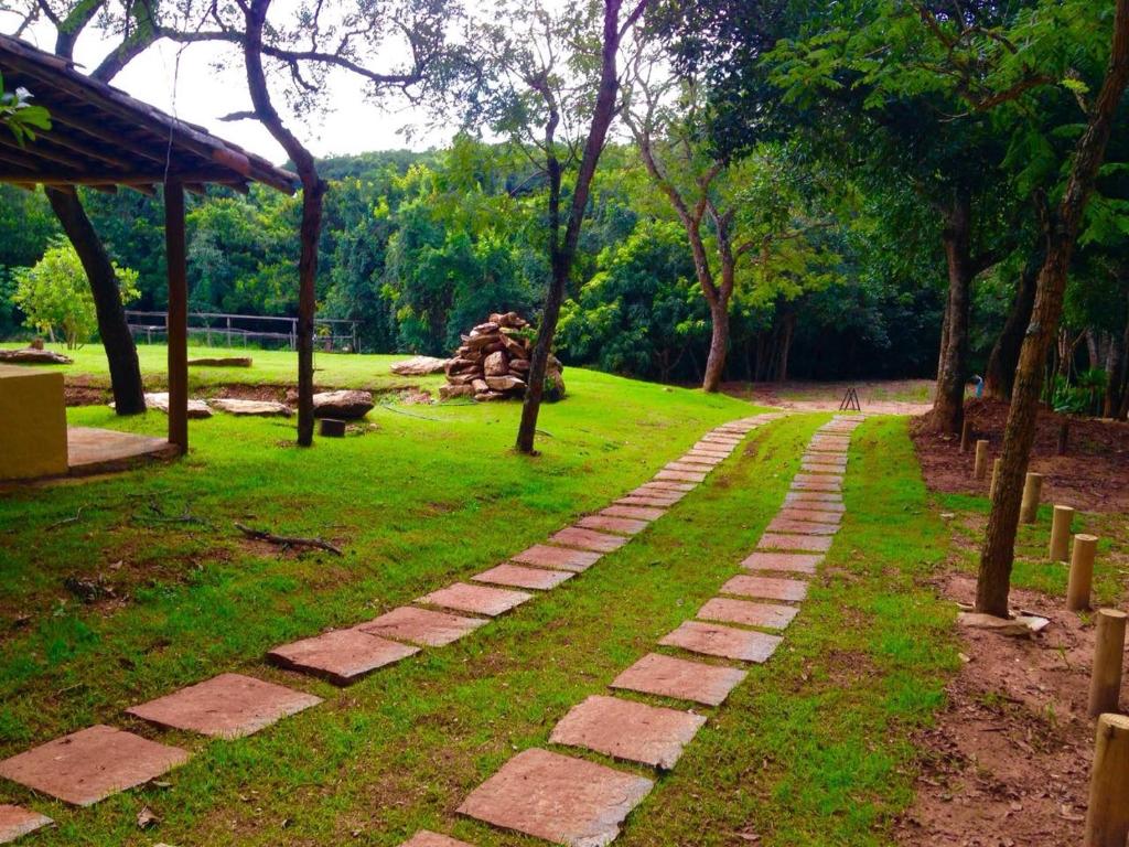 um caminho de tijolos num parque com árvores e relva em Casa em Área Rural - Delfinópolis em Delfinópolis