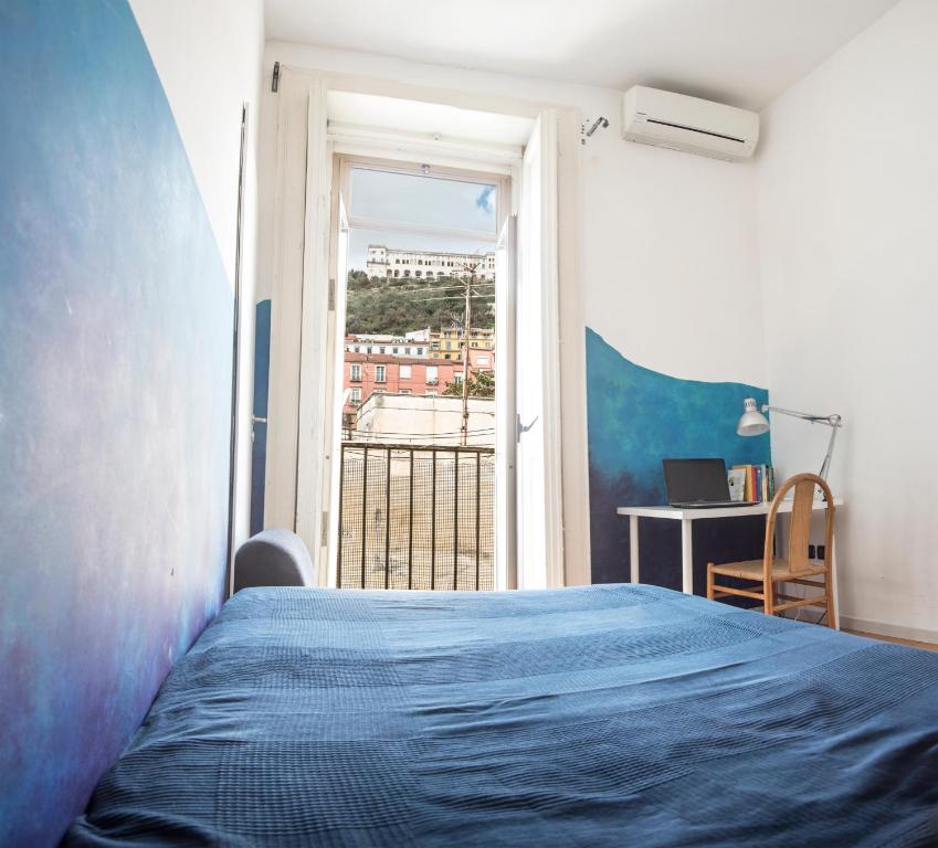 a bedroom with a blue bed and a window at La Terrazza sui Quartieri in Naples