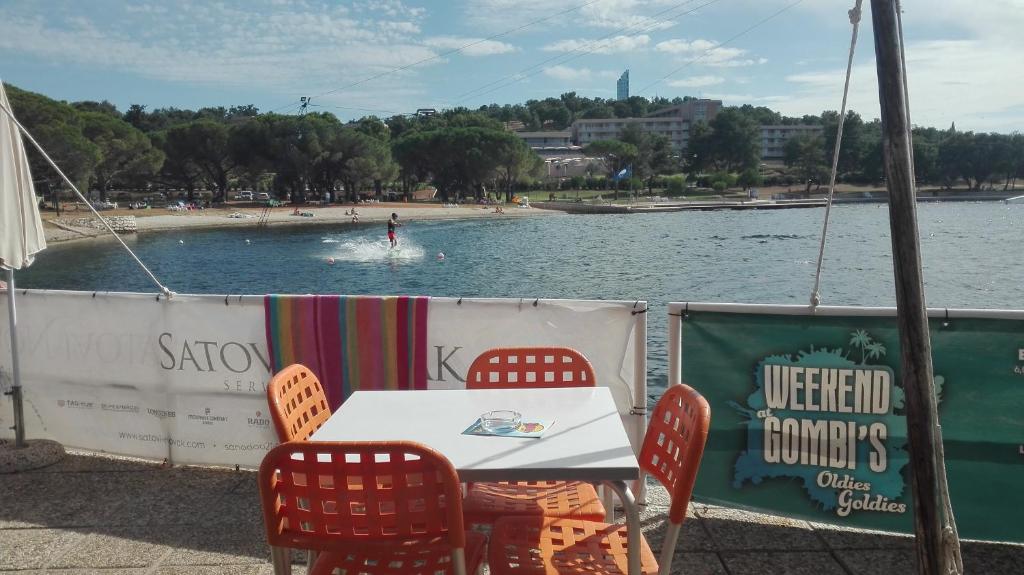a table and chairs next to a body of water at Guesthouse Porec in Poreč