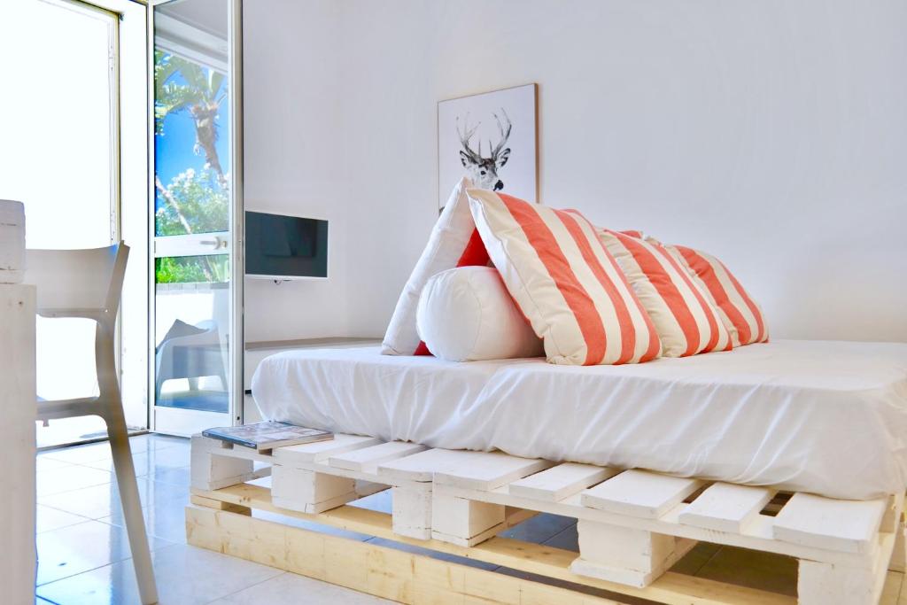 a bed with pillows on top of a wooden bench at Villa Alba in Acitrezza