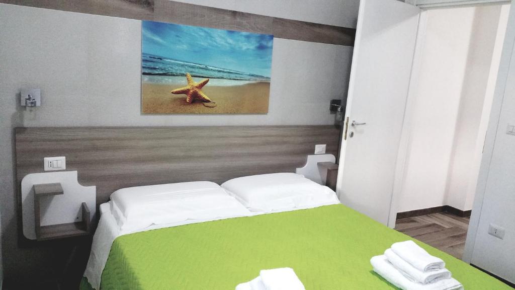 a bedroom with a green and white bed with a painting at La Bella Vita in San Vito dei Normanni