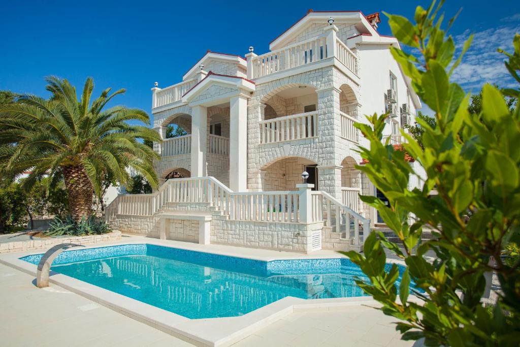 a large house with a swimming pool in front of it at Villa Drinka Apartments in Vela Luka