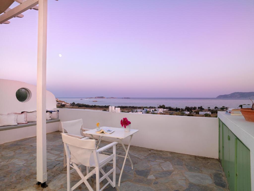 a table and chairs on a balcony with a view of the ocean at Alikaki Kimolos in Kimolos