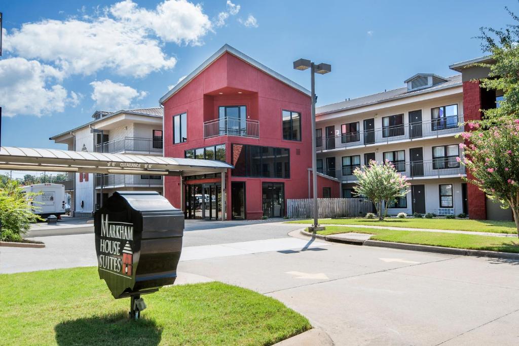 un cubo de basura frente a un edificio rojo en Markham House Suites Little Rock Medical Center, en Little Rock