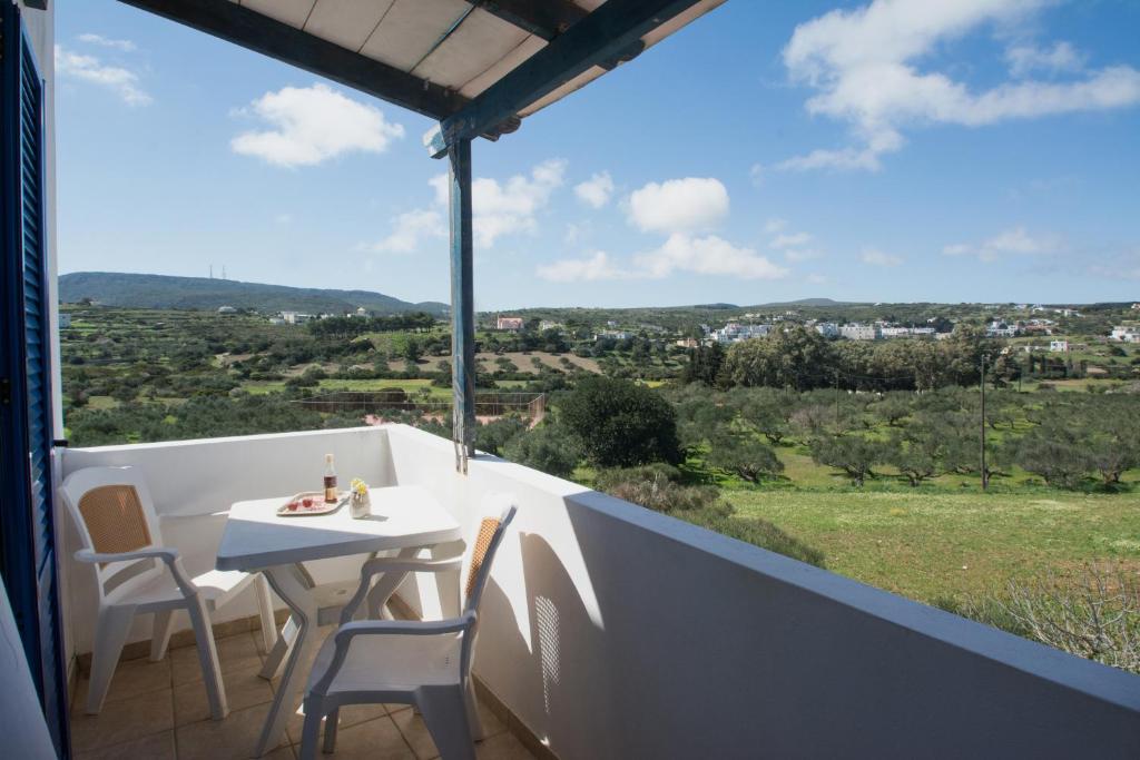 a table and chairs on a balcony with a view at Contaratos Holiday Lettings 3 in Livadi