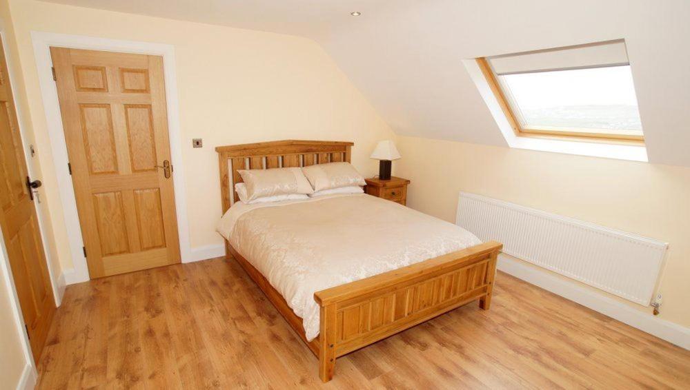 a bedroom with a bed and a skylight at Inish House in Malin Head