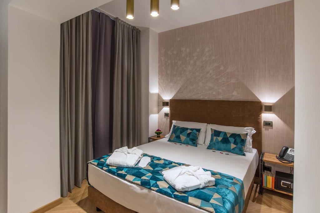 um quarto de hotel com uma cama com toalhas em Navona Essence Hotel em Roma